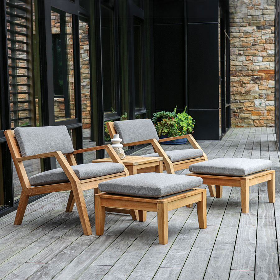 Two Hudson teak outdoor lounge chairs with cushions, pillows and ottomans.